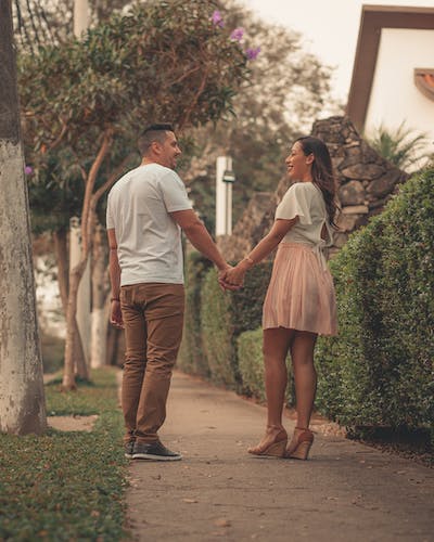 Happy couple holding hands, savoring a joyful moment together, radiating love and contentment in their shared journey.